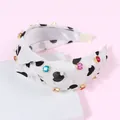 Cerchietto bianco a nodo con cuori neri, strass colorati e piccole perle bianche - Nero
