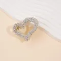 Close-up of heart-shaped hair claw clip with silver rhinestones and golden metal spring - Silver