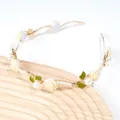 Detail eines handgefertigten Blumen-Stirnbandes mit Rosen, Perlen und grünen Blättern - Weiß