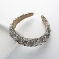 Close-up detail of a wide headband with grey shells, pearls, and a soft fabric lining - Gray