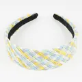Detail of colorful raffia woven headband featuring multi-colored braided texture and black lining - Blue