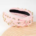Close-up of light pink fabric knotted headband with glittering crystal rhinestones - Pink