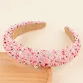 Gros plan détaillé d'un serre-tête rose épais avec strass colorés et paillettes smiley - Rose