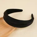 Dettaglio di un cerchietto nero bombato largo su un vassoio di legno minimalista - Nero