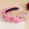 Detailaufnahme von rosa Knotenstirnband mit bunten Strasssteinen und süßen Candy-Anhängern - Rosa