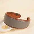 Detail eines zweifarbigen PU-Leder-Haarreifs mit feinen Nähten und mattem Finish - Grau