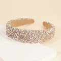 Macro detail of wide headband featuring hand-sewn rhinestones and faux pearls on a sponge base - Champagne