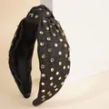 Close-up of denim knot headband featuring sparkling rhinestones with gold metal trim - Black