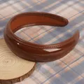 Macro detail of glossy brown PU leather padded headband with premium stitching - Brown