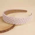 Close-up of pink headband with dense white pearls on a rustic wood stand - White