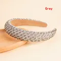Macro detail of grey rhinestone padded headband on a wooden tray with sparkling crystals - Gray
