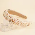 Detail of colorful crystal sponge headband placed on a luxury glass perfume bottle - Beige