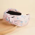 Pink floral print knotted headband with blue flowers on a natural wood tray - Pink and Blue Flowers