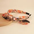 Detail of Halloween headband with orange fabric featuring bats and pumpkin print design - Yellow