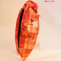 Orange plaid knotted headband with rhinestone embellishments and metallic maple leaf charms - Maple Leaf