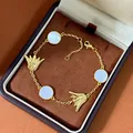 Vergoldetes Blumenarmband mit weißen Perlmuttmuscheln und Quastenblattanhängern - Messing Echtvergoldet/Natürliche Weiße Muschel / Gold Weiß