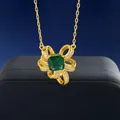 Nahaufnahme der goldenen Halskette mit Smaragd-Zirkon-Blume auf einer Schmuckbox - Halskette / Gold Halskette