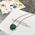 Détail du collier en or rose avec pierre verte facettée et contour en diamants pavés - Or Rose + Vert