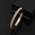 Prachtige roségouden armband met drie rijen fonkelende zirkonia stenen op een zwarte basis - Roségoud