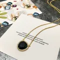 Collier élégant en or avec pendentif triangle noir et bordure en pavé de zircons - Or + Noir