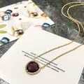 Élégant collier avec cristal violet en forme de goutte et pavé sur chaîne dorée - Or + Violet