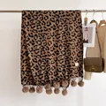 Detail of leopard print winter scarf featuring decorative plush pom-pom fringe tassels - 180x68cm / Dark Brown