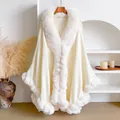 Detail eines eleganten cremeweißen Ponchos mit weichem Kunstkaninchenfellbesatz am Ausschnitt - Aprikose