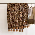 Détail de l'écharpe léopard avec des franges à pompons doux et texture tissée - 180x68cm / Fauve