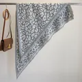 Eleganter grauer Strickschal mit Leopardenmuster und Fransen an einem Metallbügel - 180x90cm / Grau