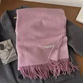 Pink wool blend long scarf with tassel edges folded on a dark grey wool coat - Lotus root pink