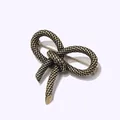 Elegant vintage brass bowknot brooch with twisted rope texture on a white background - Bronze