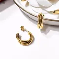 Detailed view of gold multi-layered triple hoop earrings on a decorative ceramic tray - Gold