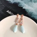 Dettaglio di orecchini pendenti in oro rosa con goccia blu opaca e zirconi a taglio marquise - Oro Rosa Blu