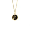 Close-up of Sagittarius star sign pendant with golden bow on a blue glitter background - Sagittarius + Black Mother of Pearl