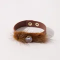 Detail van een bruine PU-lederen armband met imitatiebont en een centrale strassteen - Bruin