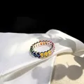 Macro shot of silver ring with colorful rainbow zircons on white silk and stone base - US 6 / Oval Rainbow Zirconia