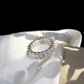 Macro shot of silver eternity ring with emerald cut cubic zirconia on silk background - US 6 / White Zircon