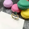 Anillo dorado con gema verde esmeralda cuadrada y diamantes sobre un macarrón rosa - Talla 6 / Borde Dorado + Azul Tinta