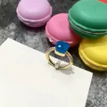 Anillo dorado con cristal azul Londres facetado y circonitas sobre cartulina - Talla 6 / Borde Dorado + Jade Azul Mar