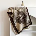 Détail d'un châle en cachemire Toile de Jouy avec pompons sur une étagère blanche - Café