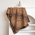 Close-up of leopard jacquard scarf fabric with fringe details and soft texture - 185x65cm / Brown