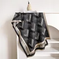 Detail eines geometrischen Strickschals mit Fransen und modernen Chevron-Mustern - 185x65cm / Schwarz