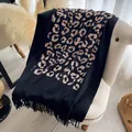 Châle noir et or à motif léopard avec franges posé sur un fauteuil blanc élégant - Noir (CX-002) / 200x70cm