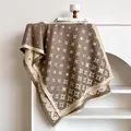 Scialle jacquard con stelle marroni e crema e frange appeso allo scaffale - Cachi