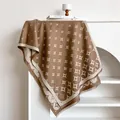 Dettaglio di uno scialle in cashmere marrone con stelle e frange fini su gruccia - Marrone Scuro