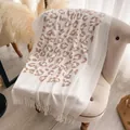 Châle pashmina à motif léopard crème avec franges drapé sur un fauteuil - Blanc (CX-004) / 200x70cm