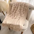 Scialle in cashmere beige con stampa leopardata e nappe su un divano bianco - Beige (CX-005) / 200x70cm