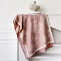 Dettaglio di sciarpa jacquard rosa con motivi floreali grigi e frange corte eleganti - 185x65cm / Rosa
