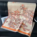 Detailed texture of beige cashmere shawl with traditional floral embroidery and orange tassels - Orange / 185x65cm