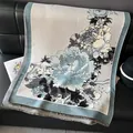 Elegante scialle pashmina jacquard con peonie e frange su un divano in pelle nera - 185x65cm / Azzurro